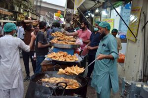 Vendors displaying samosas, kachoris, and chicken rolls to attract customers for iftari during Holy fasting month of Ramzan.