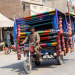 A tricycle holder on the way loaded with traditional beds (Charpai) heading toward his destination