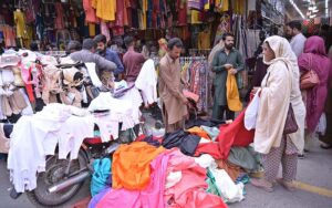 Women buying clothes from the stalls in Urdu Bazaar.