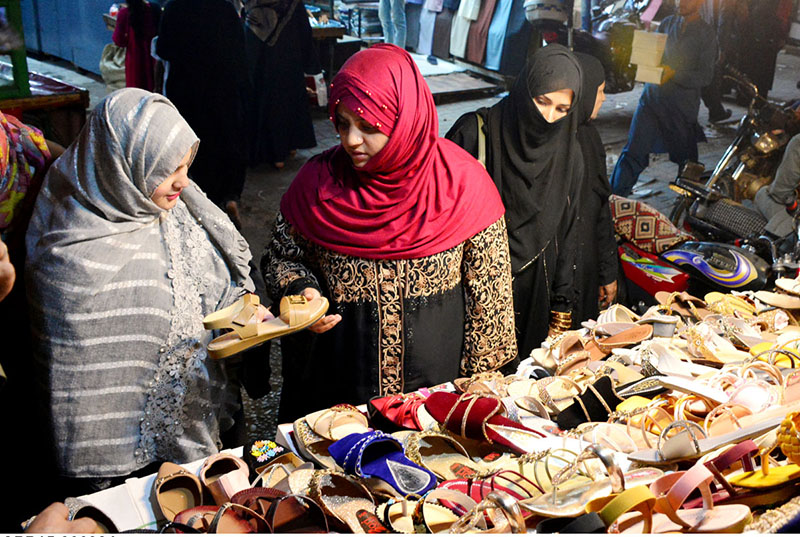 Women selecting and purchasing sandals to preparation of upcoming Eid ul Fitr.