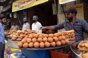 Vendors displaying samosas, kachoris, and chicken rolls to attract customers for iftari during Holy fasting month of Ramzan. 