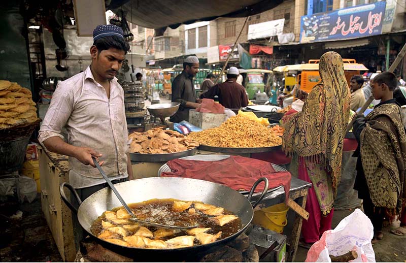 A vendor busy frying traditional food item (Samosa) for Iftar during Holy Fasting Month of Ramadan at Muslim Bazar.