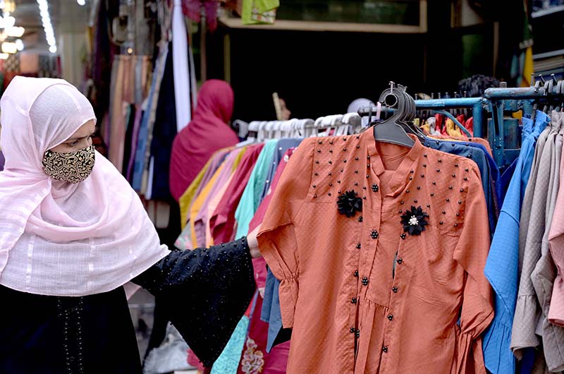 Women buying clothes from the stalls in Urdu Bazaar.