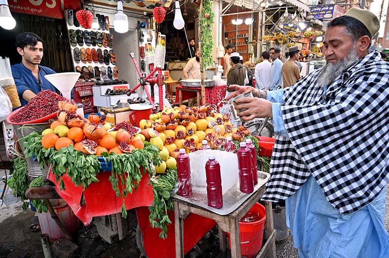 Vendor preparing and selling fresh pomegranate juice to attract the customers during Ramadan.