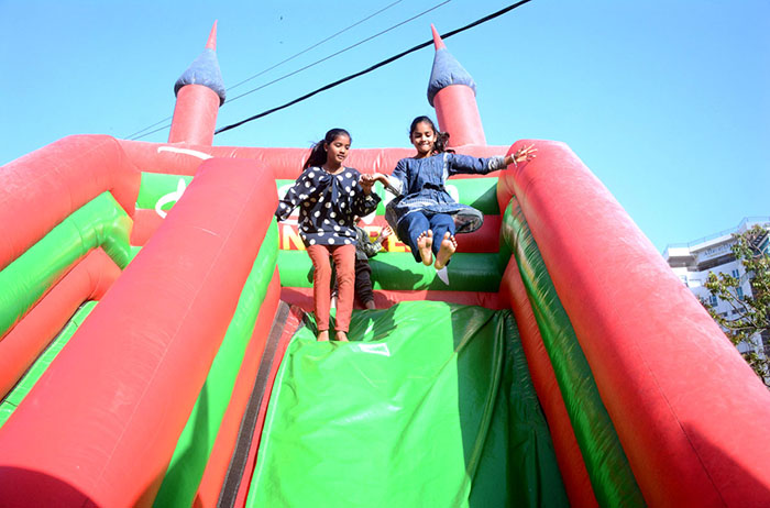 Children having fun on a slide in a public park.