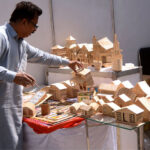 An artisan busy making small wooden items to attract customers at his workplace