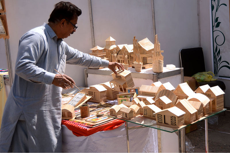 An artisan busy making small wooden items to attract customers at his workplace