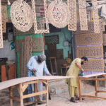 Workers are busy carving designs on the wooden sheets at their workplace