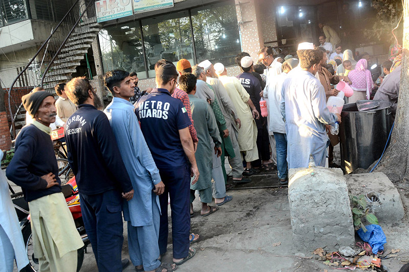 A large number of people standing in a queue to get free iftaar during Holy fasting Month of Ramadan