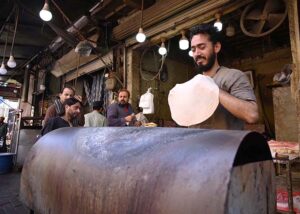 Vendor preparing traditional Chapati for customers during Ramadan.