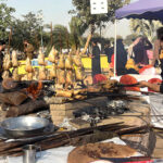 A worker prepares chicken saji over the fire during Jashan Baharan Festival at Jilani Park