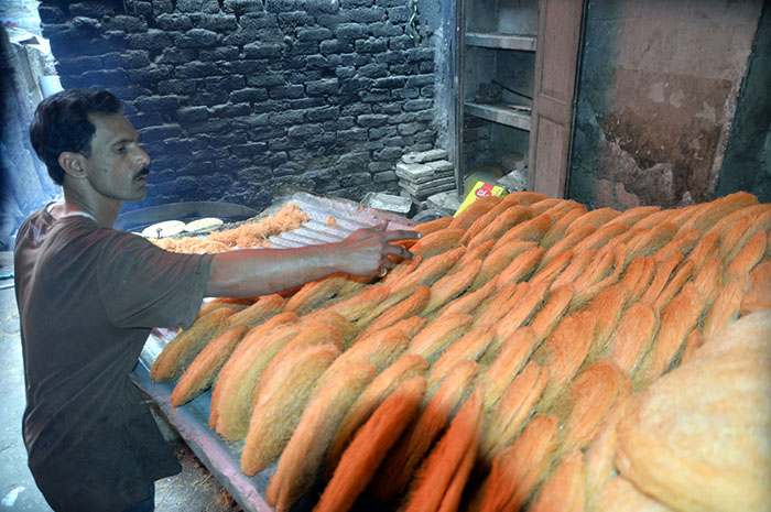 A worker preparing and arranging vermicelli (Pheoni) during Holy month of Ramadan at his workplace.