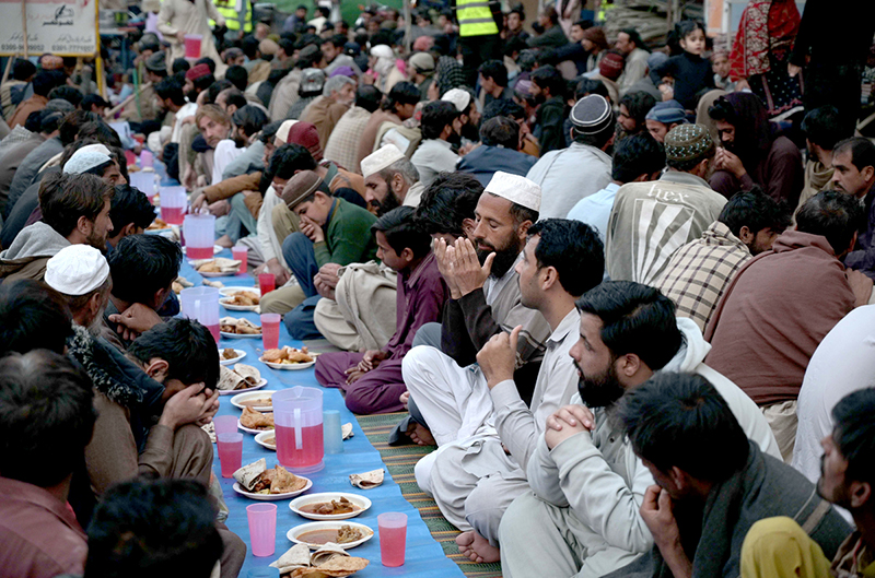People offering Dua before Iftar arranged by an NGO at Ghouri Town.