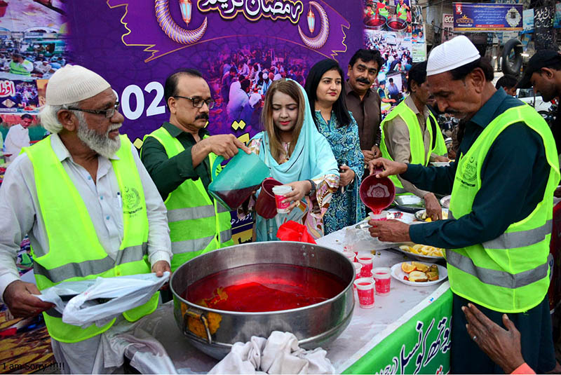 Volunteers distribute the drink for needy people sitting for Iftar arranged by Sohni Dharti Youth Council at Hyder Chowk