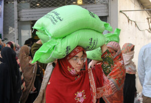 People carrying flour bags on their head provided by the Government on subsidized rate.