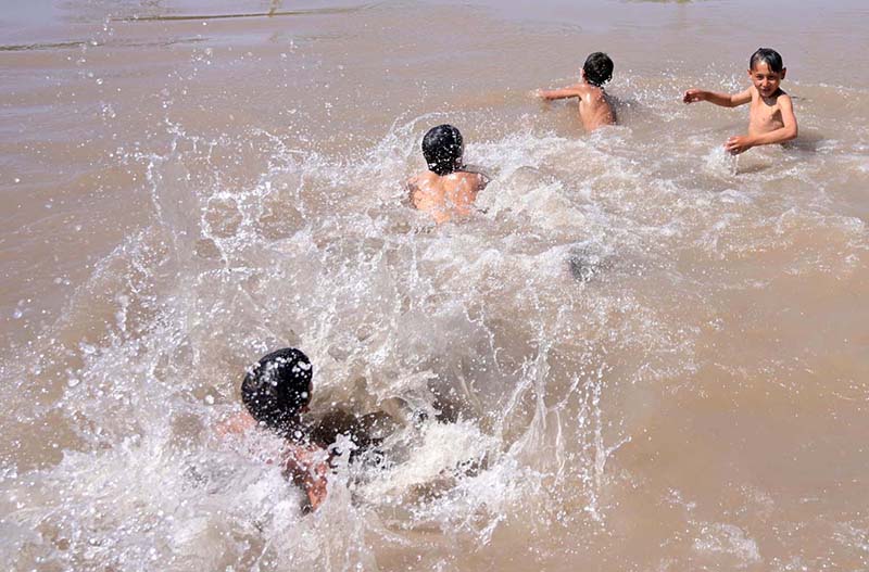 Youngsters taking bath in a canal during hot day in the city.