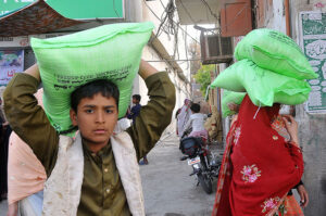 People carrying flour bags on their head provided by the Government on subsidized rate.