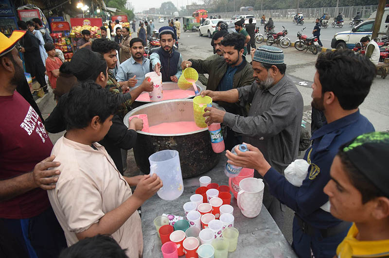Volunteers distribute the drink for needy people sitting for Iftar arranged by Sohni Dharti Youth Council at Hyder Chowk