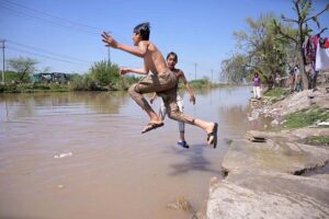 Youngsters taking bath in a canal during hot day in the city.