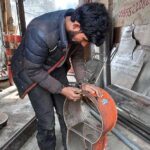 A vendor busy in compiling the parts of traditional fire stove at his workplace