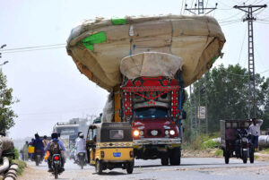 An overloaded truck on the way loaded with chaff (husk from wheat) at site area road.