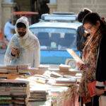 Women selecting old books at Frere Hall.