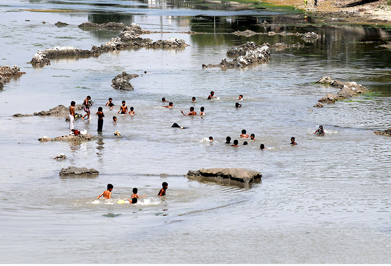 Children enjoy bath in Rice Canal to get some relief from hot weather in the city.