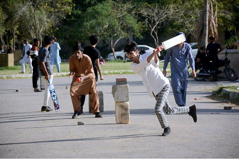 Youngsters playing cricket on road at Frere Hall