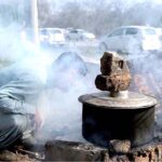 A vendor boiling sweet potatoes to sell at the bank of Rawal Lake