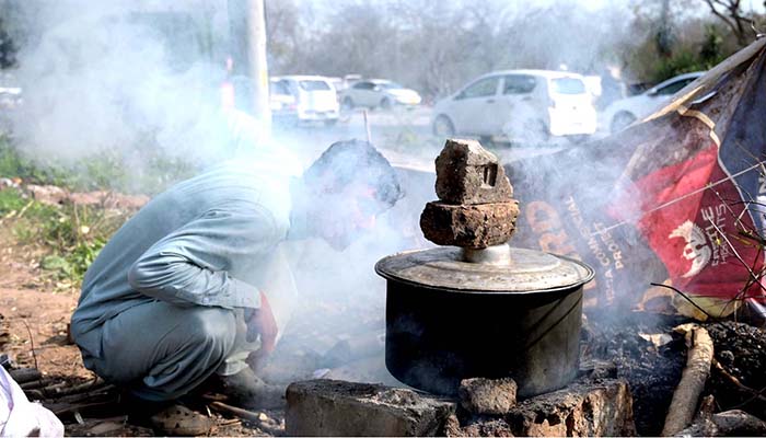 A vendor boiling sweet potatoes to sell at the bank of Rawal Lake