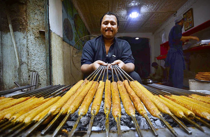 Vendor preparing traditional Seekh Kabab to attract the customers during Ramadan at Namak Mandi Road