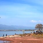 People visiting Rawal Lake during a sunny day in the city.