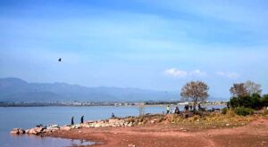 People visiting Rawal Lake during a sunny day in the city.