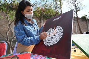 Female student busy in calligraphy during Science and Art exhibition arranged by Peshawar Model Degree Colleges