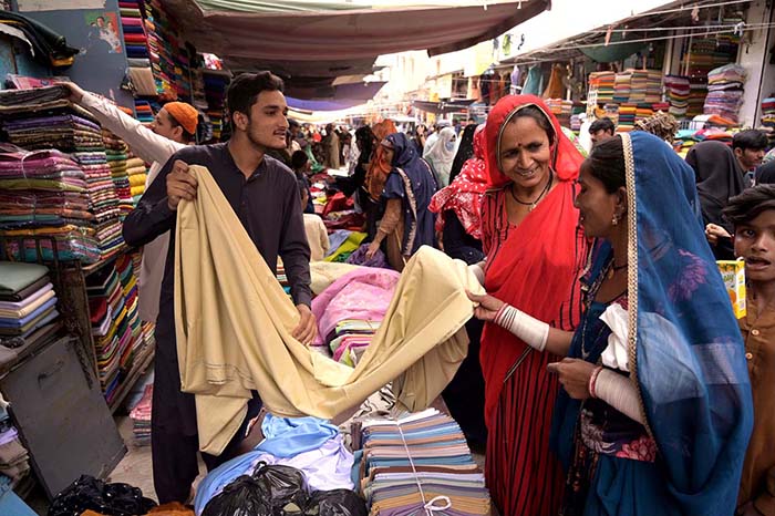 Women of Hindu community purchasing clothes for their upcoming religious festival Holi at cloth market.