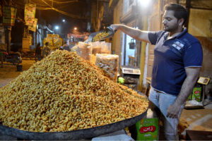 A shopkeeper displays Besan Bondi (Pakuri) to attract customers at Ghala Mandi market.