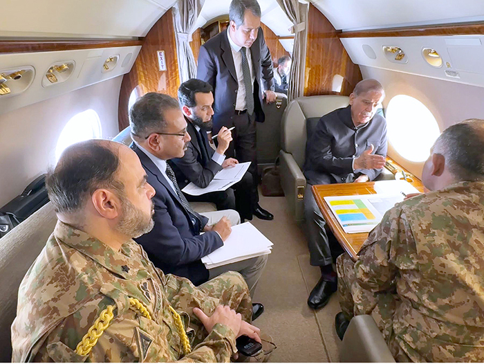 Prime Minister Muhammad Shehbaz Sharif receives briefing from Chairman NDMA Lt. General Inam Haider Malik regarding rescue and relief activities for the affectees of recent torrential rains in aircraft en route Gwadar.