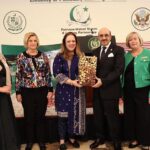 Ambassador Masood Khan addressing a jam-packed hall with a large number of women participants during an event held at the Embassy of Pakistan celebrating Pakistan's cultural treasures and the stunning landscape featuring traditional apparel, delicious cuisine, and exquisite artwork