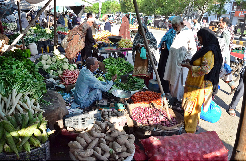 People purchasing vegetables from Ramadan Bazar on subsidized rates near Sumanabad.