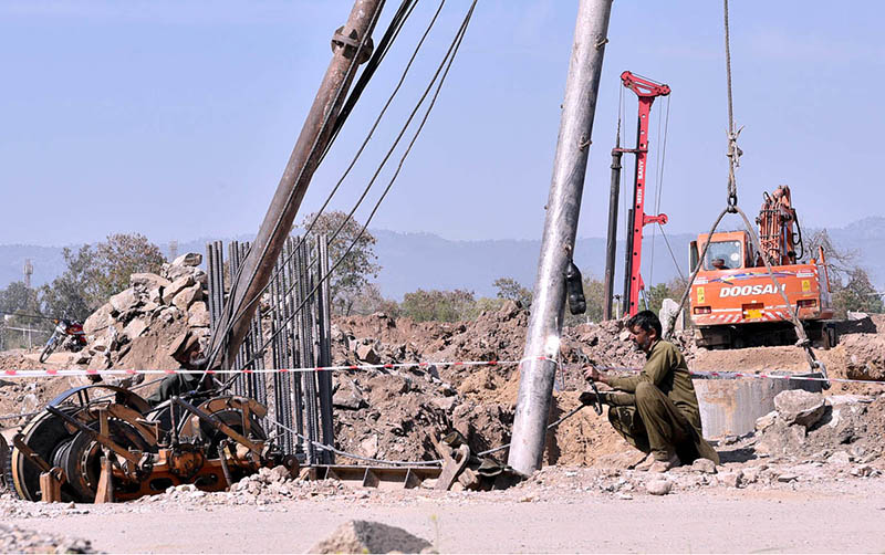 Labourer busy in construction work of Katarian Bridge Extention with the help of heavy machinery during development work in the city.