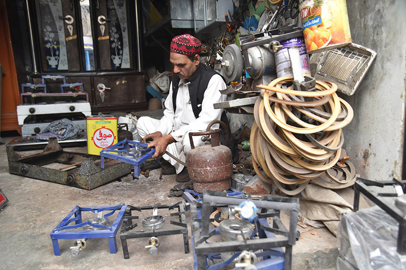 A person repairing gas cylinder stoves at his workplace