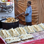 A vendor busy in preparing traditional fritter food Samosa outside his shop during Holy Fasting Month of Ramzan