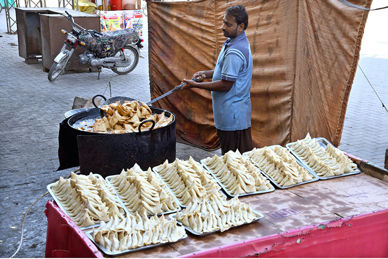 A vendor busy in preparing traditional fritter food Samosa outside his shop during Holy Fasting Month of Ramzan