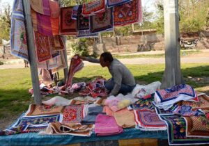 Vendor is displaying and selling bread cloth and towels to attract customers at roadside