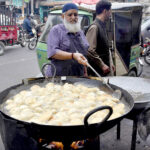 A vendor frying traditional fritter Samosa for Iftar during Holy Fasting Month of Ramadan