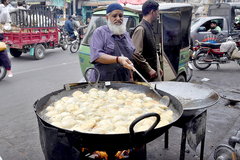 A vendor frying traditional fritter Samosa for Iftar during Holy Fasting Month of Ramadan