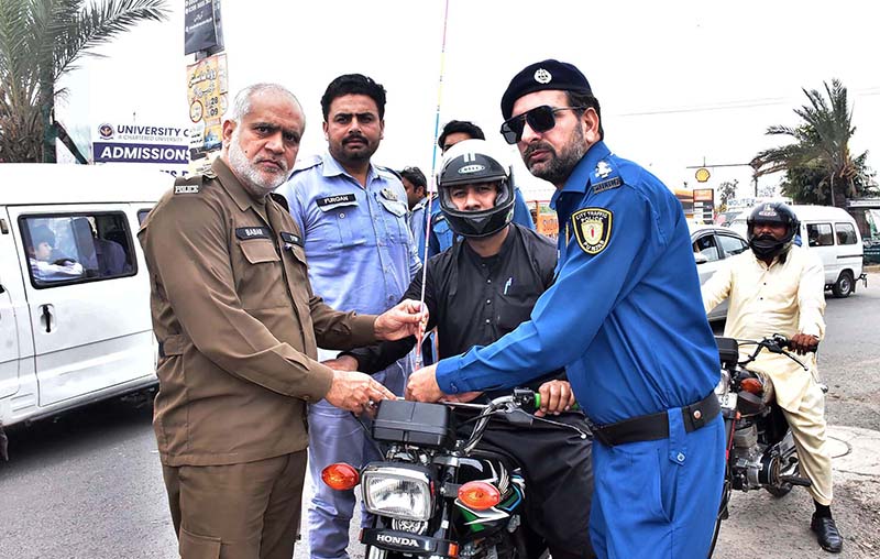 Traffic Police staffer installing free safety wires on motorcycles