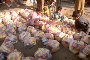 Young volunteers making food packets to distribute among the deserving people.