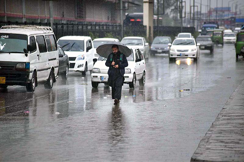 Motorcyclists on their way under the cover of an umbrella to protect from rain that experienced the Provincial Capital