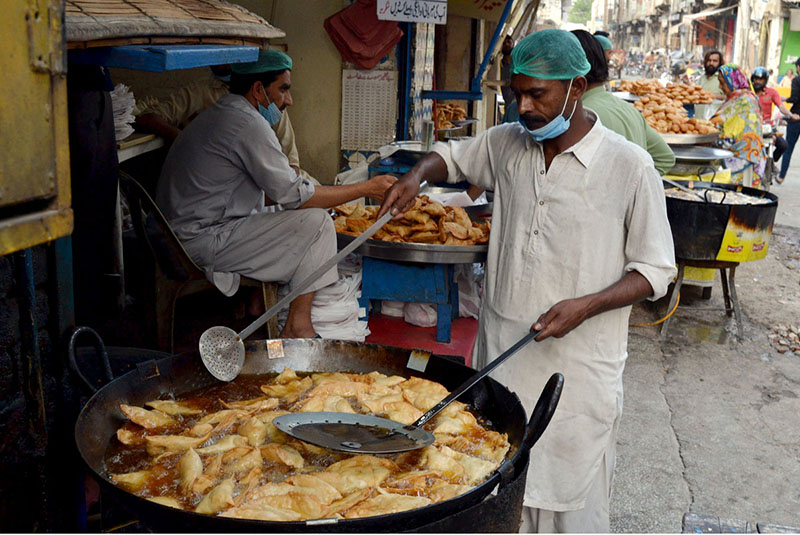 Vendors frying traditional food item for iftar at Lakshmi Food Street during Holy month of Ramzan in Provincial Capital.